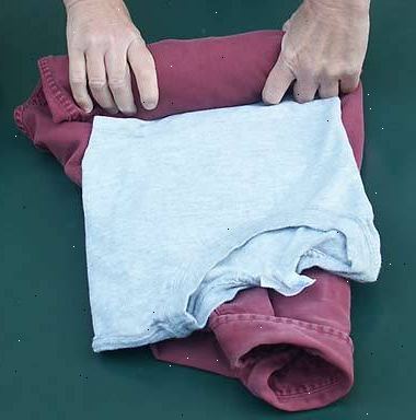 Hvordan å rulle klær. Lay hver t-skjorte på den ene siden.